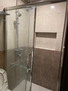 a glass shower in a bathroom with a toilet at Arkes Residential Condo Unit Rental in Baguio +6 photos