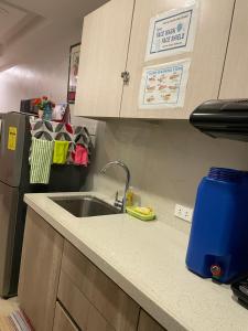 a kitchen counter with a sink and a refrigerator at Arkes Residential Condo Unit Rental in Baguio