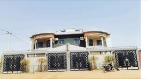 a house with a gate in front of it at Villa Amina splendid elegant structure in Ouagadougou