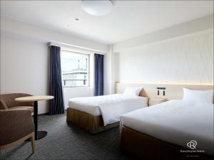 una habitación de hotel con dos camas y una silla en Daiwa Roynet Hotel Osaka-Uehonmachi, en Osaka
