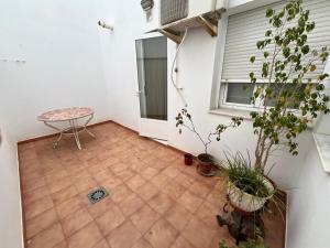 un patio con mesa y macetas en Alojamiento MB Baza, en Baza