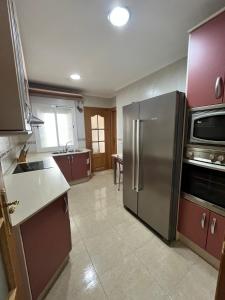 una cocina con nevera y electrodomésticos de acero inoxidable en Alojamiento MB Baza, en Baza