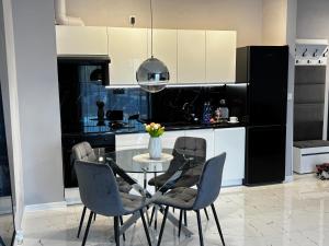 a kitchen with a table with chairs and a vase of flowers at VIA Apartments in Wałcz