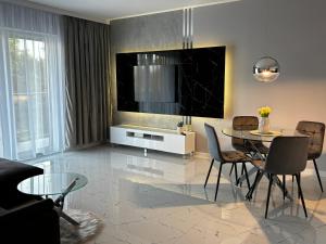 a living room with a table and chairs and a television at VIA Apartments in Wałcz