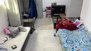 une chambre avec deux lits et un miroir dans l'établissement Shafeeq Kuri, à Ajman