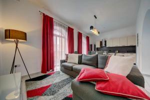a living room with a couch and red curtains at Rachel's Apartment in Paceville
