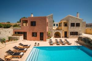 a villa with a swimming pool and lounge chairs at Phaistos Villas in Sívas