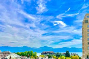 a city skyline with a blue sky and mountains at Cosy attic flat Lausanne center in Lausanne