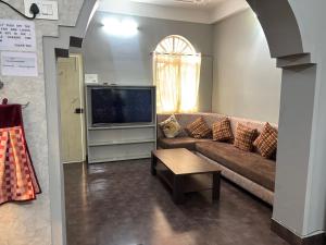 a living room with a couch and a tv at Newa House Homestay in Siliguri