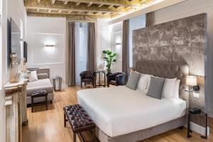 Un dormitorio con una cama grande y una sala de estar en Palazzo Goldoni Condotti Collection, en Roma 65 fotos más