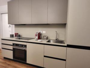 a kitchen with white cabinets and a sink at Monolocale centro storico in Novara