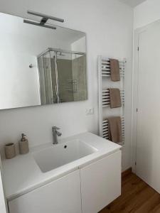 a white bathroom with a sink and a mirror at Monolocale centro storico in Novara +3 photos