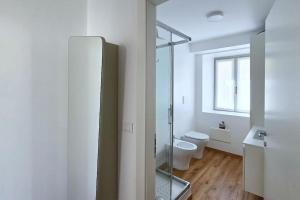 a bathroom with a toilet and a glass shower at Monolocale centro storico in Novara