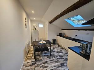 a kitchen and dining room with a table and chairs at Joli appartement mansardé in Decize