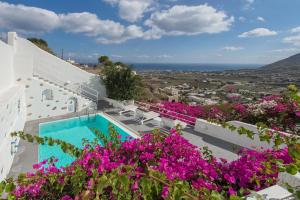 a villa with a swimming pool and flowers at White Cave Private Villa in Pyrgos