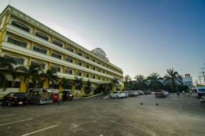 un grand bâtiment avec des voitures garées dans un parking dans l'établissement Ranong Garden Hotel, à Ranong