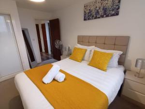 a bedroom with a large bed with yellow pillows at Broad St 1-Bed Sleeps 2 with Free Parking in Birmingham