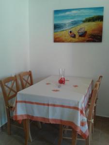 een tafel met een witte en rode tafeldoek erop bij Maria's Apartments in Meyisti