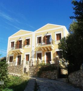 a large white building on top of a stone wall at Maria's Apartments in Meyisti