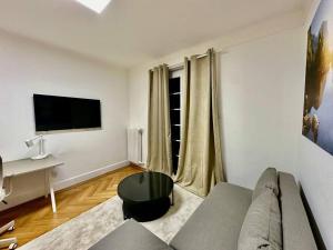 a living room with a couch and a table at Cosy studio a Lausanne center in Ouchy