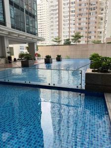 a large swimming pool in a building with tall buildings at Rustic Elegance New One Bedroom One Uptown Free parking in Manila +8 photos