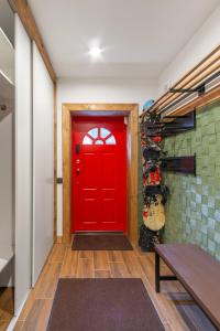 a red door in a hallway with a bench at Двоповерховий апартамент у котеджі FREEMAN-4b з альтанкою та грилем - вздовж ділянки маленька річка in Bukovel