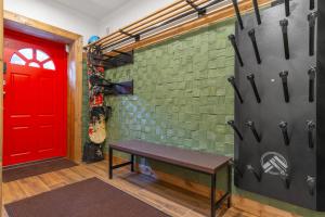 a red door and a bench in a room at Двоповерховий апартамент у котеджі FREEMAN-4b з альтанкою та грилем - вздовж ділянки маленька річка in Bukovel +45 photos