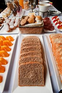 una mesa llena de diferentes tipos de pan y repostería en Hotel Naguilan, en Valdivia