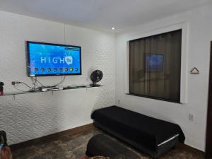 a living room with a flat screen tv on a wall at Casa de temporada Xerém in Duque de Caxias