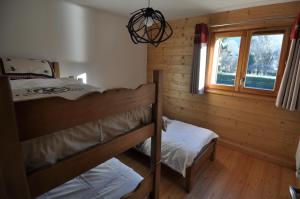 a bedroom with two bunk beds and a window at Résidence Les Chardons Argentés in Samoëns