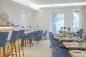 a dining room with tables and blue chairs at Pagoda Lifestyle Hotel in Ischia