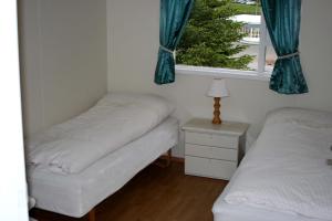 Postel nebo postele na pokoji v ubytování Hofdi Guesthouse + 3 fotografie
