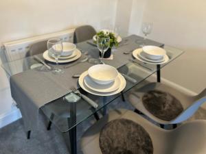 a dining table with glasses and plates on it at Radbourne House - Spacious 2 Bed, Home from Home in Derby in Derby +31 photos
