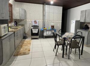 a kitchen with a table and chairs in it at Sítio recanto da Felicidade in Gravataí