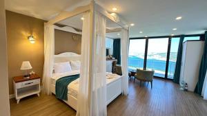 1 dormitorio con cama con dosel y vistas al océano en Aden Boutique Otel, en Cesme 56 fotos más