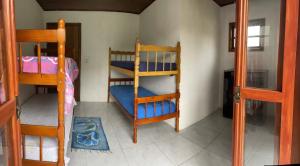 a room with two bunk beds and a doorway at Sítio recanto da Felicidade in Gravataí