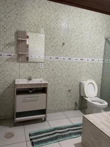 a bathroom with a toilet and a sink and a mirror at Sítio recanto da Felicidade in Gravataí