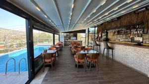 un restaurante con piscina y un bar con mesas y sillas en Aden Boutique Otel, en Cesme