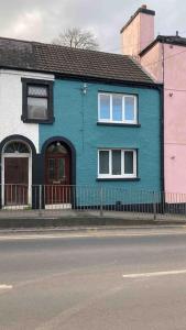 a blue house on the side of a street at Quaint Cottage main street Llandeilo in Llandeilo
