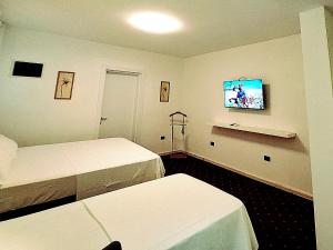 Una habitación de hotel con dos camas y un televisor de pantalla plana. en Titi Luxury&Spa, en Ulcinj