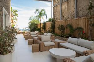 a patio with wicker chairs and tables on a building at Pagoda Lifestyle Hotel in Ischia