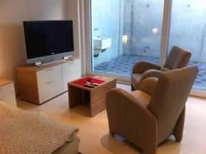 a living room with a tv and two chairs and a televisionictericter at Sunrise Apartment in Staad