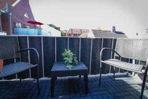 a patio with two chairs and a table and a plant at La Bella Vita in Emden