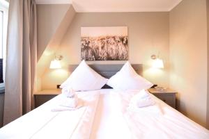 a bedroom with a bed with white sheets and pillows at La Bella Vita in Emden