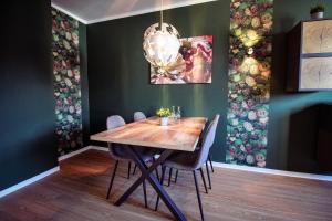 a dining room with a wooden table and a chandelier at La Bella Vita in Emden +12 photos