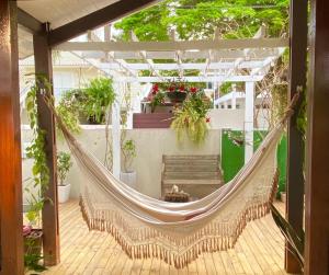 una hamaca en medio de un patio con plantas en Casa Madre Hostel Feminino, en Florianópolis 29 fotos más