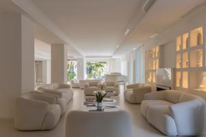 a living room with white chairs and a table at Pagoda Lifestyle Hotel in Ischia