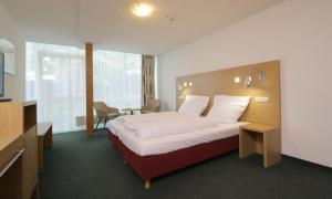 ニュームブレヒトにあるKaspers Gästehausの大きなベッドと机があるホテルの部屋