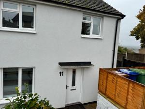 a white house with a white door at Florina s House 4 Bedrooms Villa in Rugeley