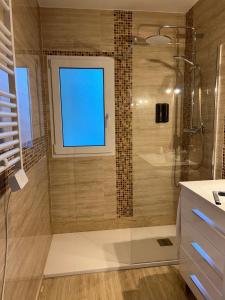 a bathroom with a glass shower with a window at Primavera Premium Sierra Nevada 4 in Sierra Nevada